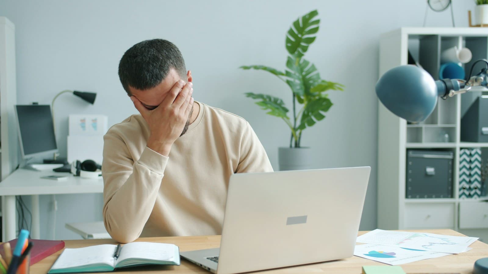 A founder with his hand over his face at a laptop